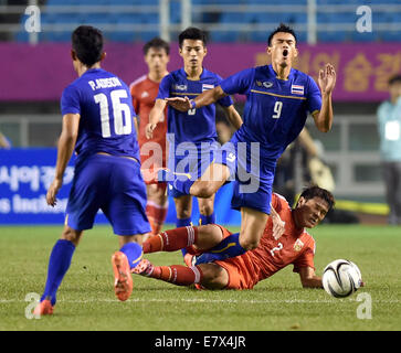 (140925)--INCHEON, 25. September 2014 (Xinhua)--Kraisorn Adisak (obere R) von Thailand konkurriert im Männerfußball Runde der 16 Spiel gegen China bei der 17. Asian Games in Incheon, Südkorea, 25. September 2014. China verlor 0: 2. (Xinhua/Lo Ping Fai) (Mcg) Stockfoto