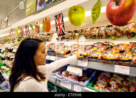 Junge Frau shopping / Kauf Englisch Obst produzieren in Waitrose Supermarkt, Newmarket, Suffolk, Großbritannien Stockfoto