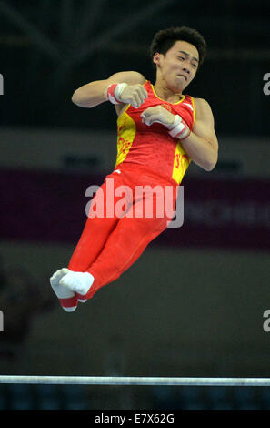 (140925)--INCHEON, 25. September 2014 (Xinhua)--Zou Kai (vorne) von China führt, während die Männer Reck-Finale der Gymnastik künstlerisches Ereignis bei den 17. Asian Games in Incheon, Südkorea, 25. September 2014. Zou Kai gewann die Goldmedaille mit 15,800 Punkten. (Xinhua/Zhu Zheng) (Mcg) Stockfoto