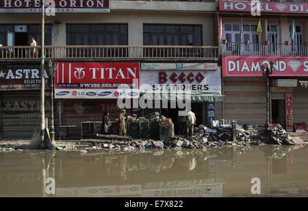 Kaschmir, Indien. 25. Sep, 2014. Kashmiri Frau vorbeigehen waren Bergungen in einem beschädigten Markt durch die jüngsten Überschwemmungen in Srinagar, Sommer in der Hauptstadt von Indien kontrollierten Kaschmir, 25. September 2014. Regierung von Indien kontrollierten Kaschmir ist wahrscheinlich zu unterbreiten, die indische Regierung ein Memorandum von Verlusten, auf mindestens 50.000 geschätzt crore indischen Rupien in der kommenden Woche. Die Rekord Überschwemmungen in mehr als einem Jahrhundert schlug Indien kontrollierten Kaschmir führten Hunderte von Menschen getötet und Zehntausende obdachlos. Bildnachweis: Xinhua/Alamy Live-Nachrichten Stockfoto