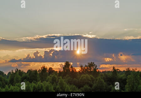 Sonnenuntergang - die Sonne scheint durch eine Wolke. Stockfoto