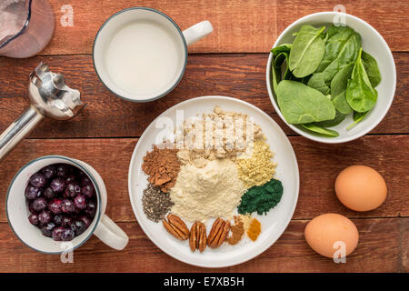 Zutaten für gesundes Frühstück Smoothie: Mandelmilch, rohen Eiern, frischem Spinat, gefrorene Blaubeeren, Molkenprotein Stockfoto