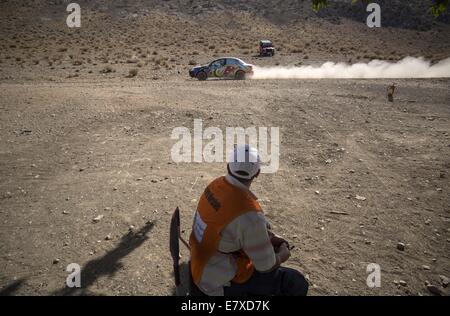 Teheran, Iran. 25. Sep, 2014. 25. September 2014 - Teheran - eine iranische Sicherheit auf ein Auto blickt fährt vorbei während der 2014 Nahost-Rallye-Meisterschaft in der Nähe der Stadt von Shiraz in Fars Provinz etwa 900 Meilen (559) südlich von Teheran. Morteza Nikoubazl/ZUMAPRESS Credit: Morteza Nikoubazl/ZUMA Draht/Alamy Live-Nachrichten Stockfoto