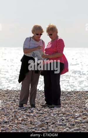 Cuckmere Haven, East Sussex, England. 25. September 2014. Zwei Damen auschecken ihre Karte nach dem Weg und genießen die Sonne und Meer Brise am Strand von Cuckmere Haven. Bildnachweis: Julia Gavin UK/Alamy Live-Nachrichten Stockfoto