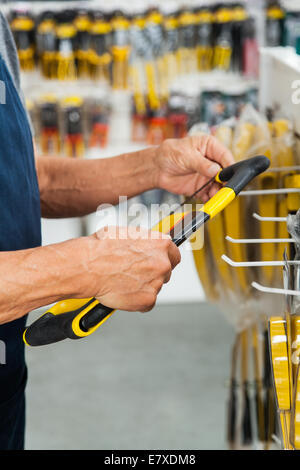 Verkäufer-Holding-Säge im Store Stockfoto