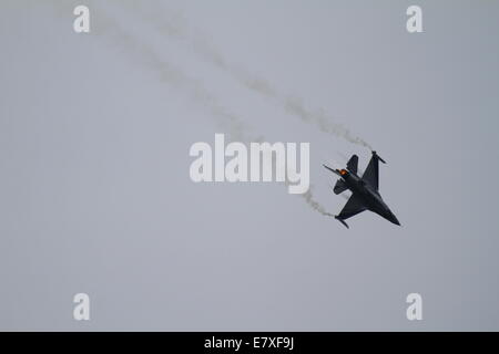 Palaio Faliro, Griechenland. 25. September 2014. BIN eine f-16 Fighting Falcon von der belgischen Luftwaffe schafft braun Kondensstreifen, wie es über das Meer in Palaio Faliro fliegt. Die public Displays von Tatoi Flugschau, ist Teil der 3. Athen fliegen Woche begann mit einer Pre-Show mit Fly over an der Küste von Palaio Faliro in der Nähe von Athen. Bildnachweis: Michael Debets/Alamy Live-Nachrichten Stockfoto