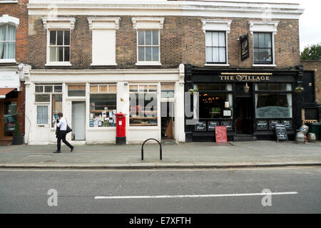 Junge, vorbei an der Dorfkneipe und Geschäfte in Orford Road, Walthamstow Village, London E17 KATHY DEWITT Stockfoto