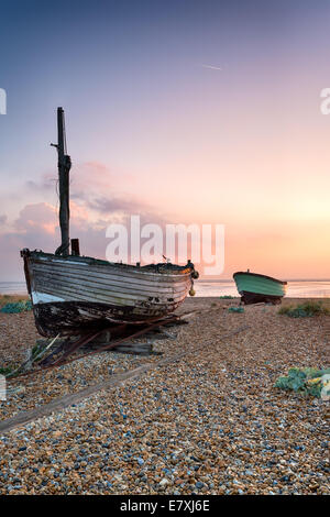 Schönen Sonnenaufgang über dem alten Holzboote auf einem Kiesstrand in Lydd, Kent Stockfoto