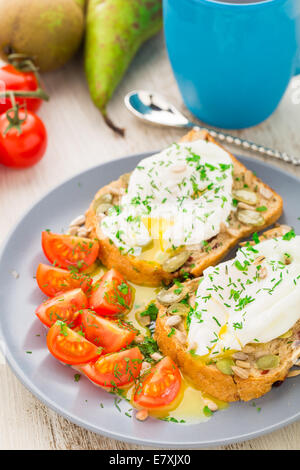 Sandwich mit pochiertem Ei und Cherry-Tomaten Stockfoto