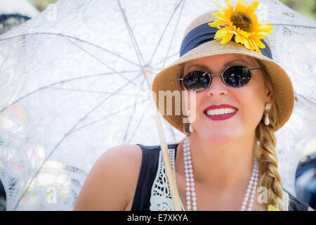 Junge attraktive Frau in zwanziger Jahre Outfit mit Sonnenschirm. Stockfoto