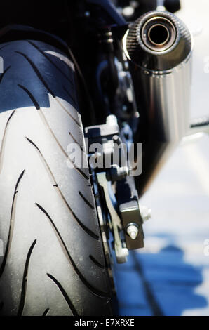 Nahaufnahme von Hinterrad und Auspuffrohre eines Motorrads. Stockfoto