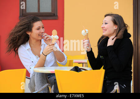 Zwei Freundinnen, Teenager, Essen ein Eis aus Kegel auf der Terrasse einer Eisdiele, Menton, Alpes-Maritimes Stockfoto