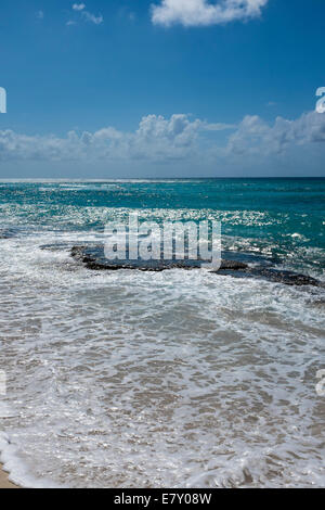 Ozean bricht über ein flaches Riff auf den Strand auf Barbados. Stockfoto