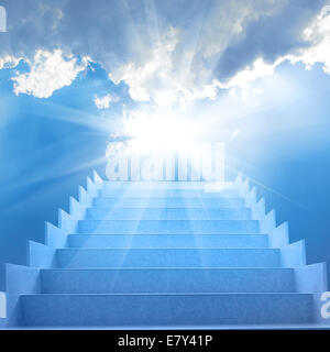 Treppe im Himmel. Konzept mit Treppe, Sonne, weiße Wolken und blauem Hintergrund Stockfoto
