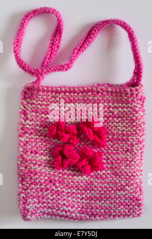 Rosa gestrickte Tasche mit rosa Blüten isoliert auf weißem Hintergrund Stockfoto