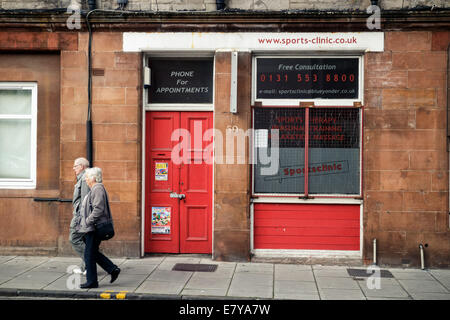 Altes Ehepaar vorbei an einem geschlossenen Sportklinik, Leith, Edinburgh Stockfoto