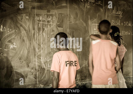 Drei junge Studenten schreiben auf einer Tafel im Klassenzimmer. Hell-Ville-Schule. Madagaskar. Stockfoto