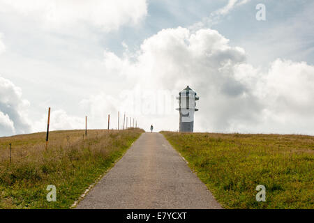 Weg, um einen Turm in den grünen Rasen und Wolken am Berg Stockfoto