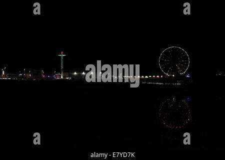 Nacht-Strandblick, mit Reflexionen, nach Süden in Richtung Central Pier "Big Wheel" und "Sky Flye an Spitze der Fahrt, Blackpool Illuminations Stockfoto