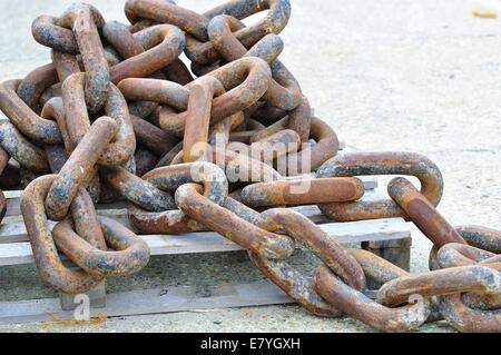 Ein Stapel rostiger, robuster Eisenketten auf Holzpaletten am Hafen, Lyme Regis, Dorset, England, Großbritannien Stockfoto