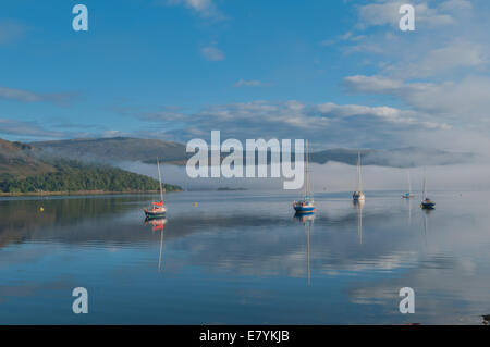 Yachten auf Loch Linnhe im Morgennebel Fort William Lochaber Hochland Schottland reflektiert Stockfoto