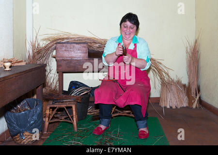 Eine Frau macht Reed Möbel in ein Geflecht-Fabrik in Madeira, Portugal. Stockfoto