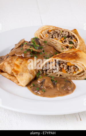 Bohnenkraut Hackfleisch Pfannkuchen oder Tortillas aufgeschnitten, der Boden oder Hackfleisch / Faschiertes und Gemüse füllen in einer reichen leckere Soße zu zeigen Stockfoto