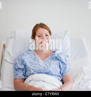 Blick auf Frau im Krankenhausbett liegen und lächelnd Stockfoto