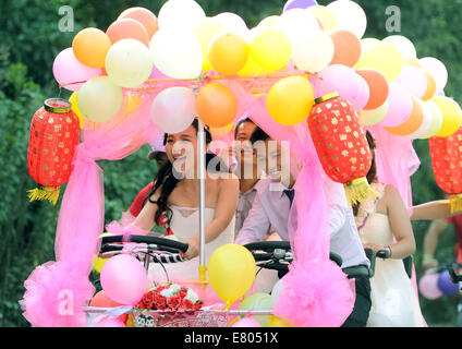 Der Provinz Hunan Changsha, China. 27. Sep, 2014. Jiang Yan Braut und Bräutigam Huang Bo Fahrrad ein Vierrad Hochzeit in Changsha, der Hauptstadt der Provinz Zentral-China Hunan, 27. September 2014. Das Paar, zusammen mit ihren Kumpels Reiten feierten ihre Hochzeit von Fahrrad am Samstag. Bildnachweis: Li Ga/Xinhua/Alamy Live-Nachrichten Stockfoto