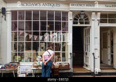 Sidmouth, Devon, England. Ein einziges erwachsenen Weibchen sieht durch das Fenster ein Antiquitätengeschäft an der Hauptstraße von Sidmouth. Stockfoto