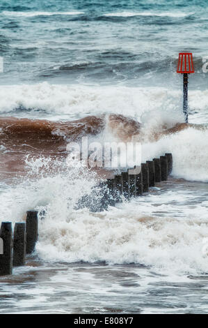 Wellen, die über eine Mole an einem britischen Strand Stockfoto
