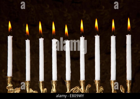 Chanukka-Kerzen brennen, in eine Menora auf schwarzem Hintergrund Stockfoto