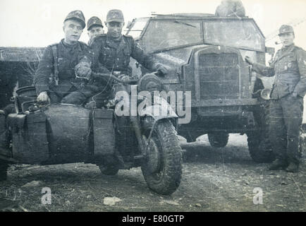 Deutsche Soldaten posiert auf einem Motorrad auf dem Hintergrund der Militär-LKW, Deutschland, 1940er Jahre. Reproduktion von antiken Foto. 27. Sep, 2014. © Igor Golovniov/ZUMA Draht/Alamy Live-Nachrichten Stockfoto