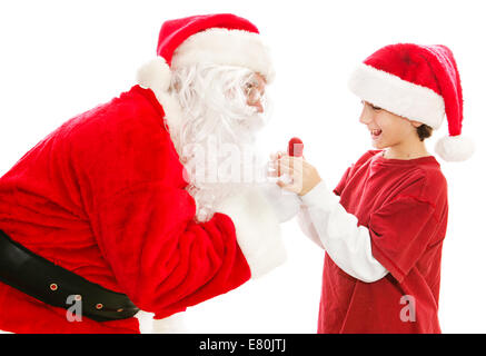 Santa Claus verleiht Weihnachten Lollipop einem niedlichen kleinen Jungen.  Isoliert auf weiss. Stockfoto