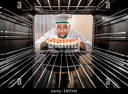 Chefkoch Pizza in den Ofen, Blick aus dem Inneren des Ofens. Kochen in den Ofen. Stockfoto