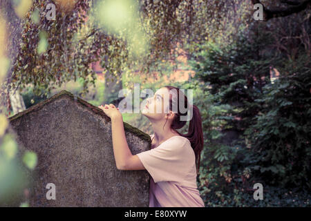 Vintage-Shooting einer Frau berühren einen Moos überwachsen Grabstein Stockfoto