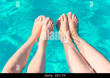 zwei weibliche Beinpaare im pool Stockfoto