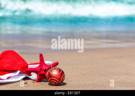 Weihnachtsmann-Mütze auf dem Sand am Meer Stockfoto