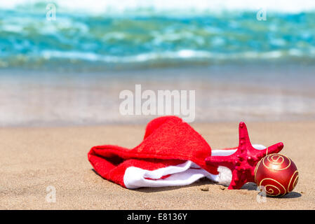 Weihnachten-Attribute und Seestern am Strand Stockfoto