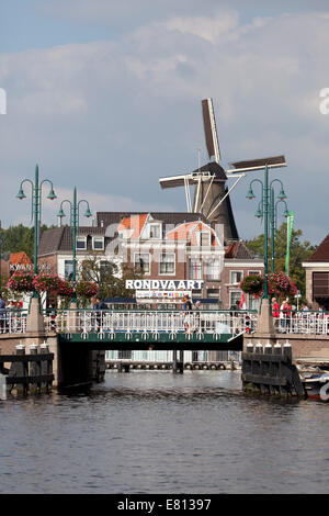 Blauwpoortsbrug in der Stadt Leiden mit einer Windmühle de Valk im Hintergrund, Niederlande Stockfoto