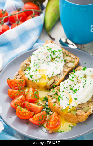 Sandwich mit pochiertem Ei und Cherry-Tomaten Stockfoto