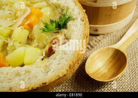 Kohlsuppe im Brotlaib auf einem Holztisch Stockfoto