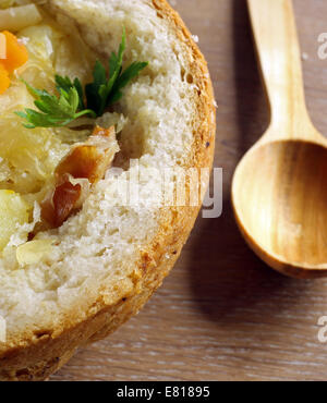 Kohlsuppe im Brotlaib auf einem Holztisch Stockfoto