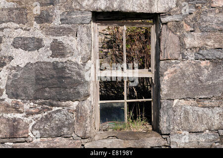 Alte und defekte Schiebefenster in einem Stein baute verfallenen Croft in der Isle of Lewis. Stockfoto
