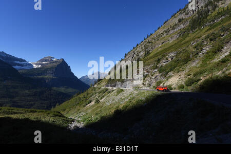 Eine rote Jammer Bus auf dem Weg zum Sun Road im Glacier National Park, Montana. Stockfoto