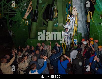 Internationale Raumstation ISS-Expedition 41 Besatzungsmitglieder, Alexander Samokutyaev von der russischen Federal Space Agency, unten, Astronaut Barry Wilmore der NASA, Center und Elena Serova Welle vor dem Einsteigen in das Raumschiff Sojus TMA - 14 M für den Start zur internationalen Raumstation ISS 25. September 2014 in Baikonur, Kasachstan. Samokutyaev, Serova und Wilmore verbringen die nächsten fünfeinhalb Monate Leben und arbeiten an Bord der ISS. Stockfoto