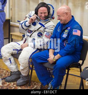 Internationale Raumstation ISS-Expedition 41 Astronaut Barry Wilmore der NASA spricht mit backup Crew-Mitglied Flugingenieur Scott Kelly, wie er wartet auf seine russische Sokol Raumanzug Druck in Vorbereitung für den Start an Bord der Sojus TMA - 14 M-Sonde zur internationalen Raumstation ISS 25. September 2014 in Baikonur, Kasachstan überprüft haben. Samokutyaev, Serova und Wilmore verbringen die nächsten fünfeinhalb Monate Leben und arbeiten an Bord der ISS. Stockfoto