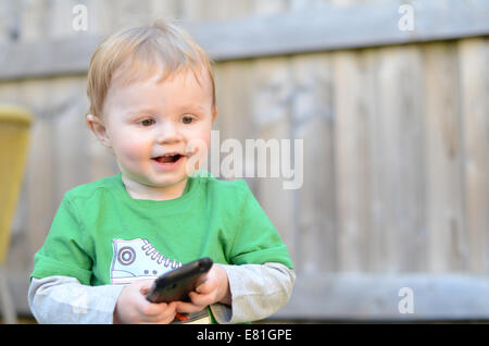 Zwei Jahre alten Jungen spielen mit Mobile Smart Phone Stockfoto