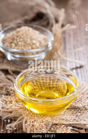 Sesamöl in einer kleinen Schüssel auf Vintage Holz-Hintergrund (close-up erschossen) Stockfoto