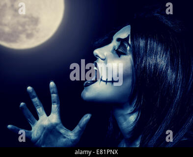 Closeup Portrait von furchterregenden Hexe schreien im Vollmond, aggressive Frau mit gruseligen Make-up schreien vor Halloween Feiertag Stockfoto